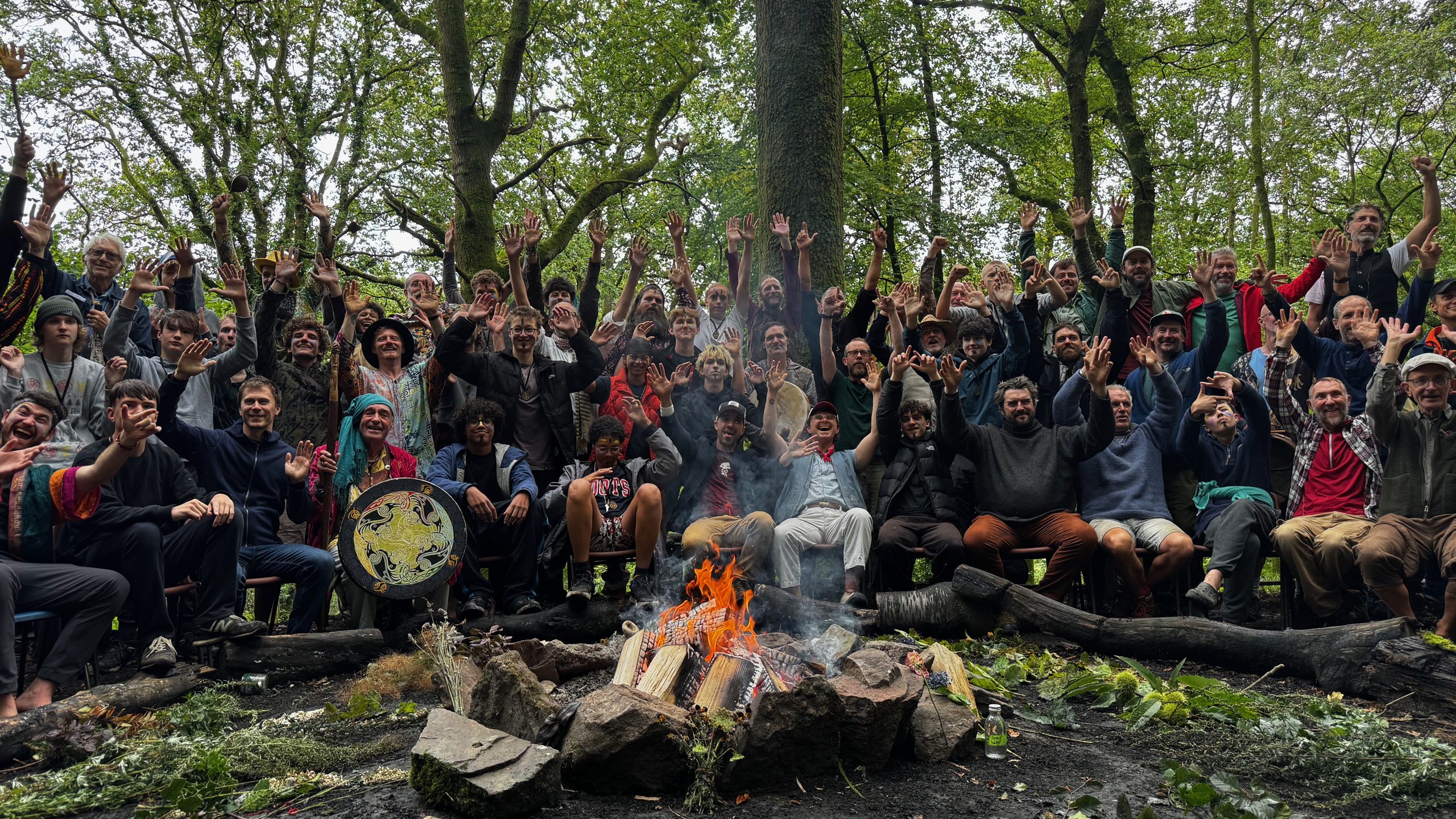 Boys and men waving around the fire in the woods