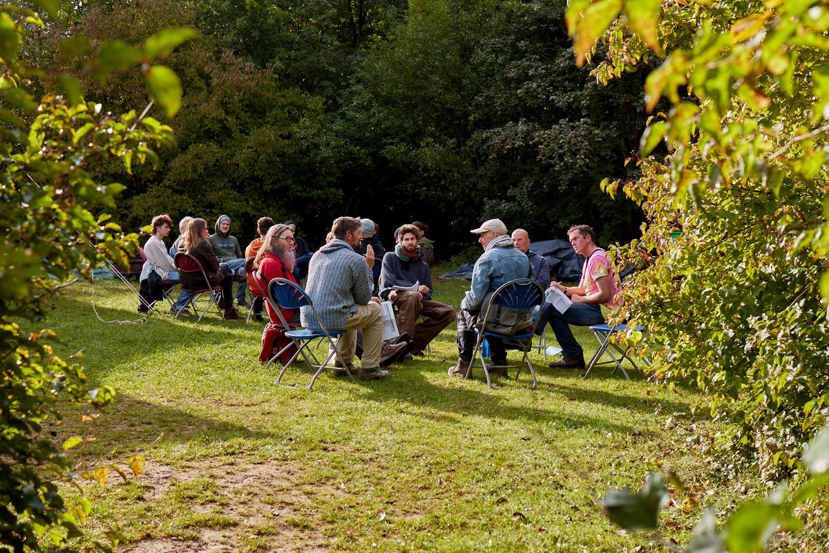 Mentors and boys sitting in a circle on the grass