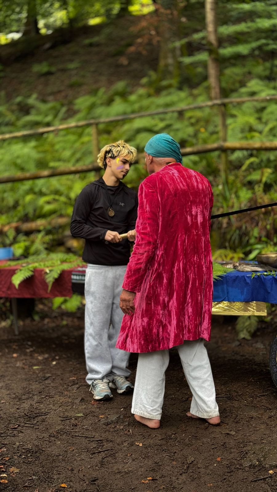 A mentor in a pink robe standing with a boy
